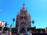 the Parish Church of San Miguel Arcangel with Gothic spires and a pink-colored façade.
